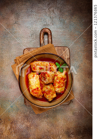 Stuffed cabbage rolls with minced meat, in tomato sauce, top view, without people, in the spotlight. 121376865