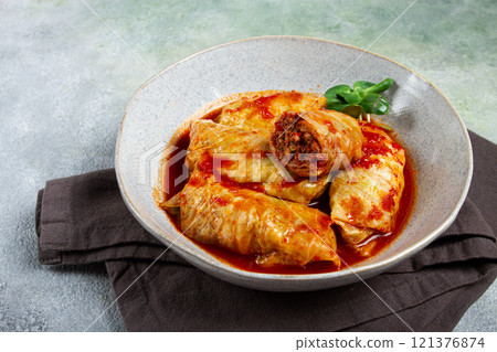 Stuffed cabbage rolls with minced meat, in tomato sauce, top view, without people, in the spotlight. 121376874