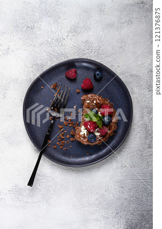half-eaten chocolate tartlet, on a plate, stuffed with cottage cheese and berries, breakfast, homemade, no people, half-eaten chocolate tartlet, on a plate, stuffed with cottage cheese and berries, breakfast, homemade, no people, 121376875