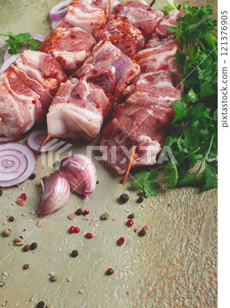 raw pork meat, on wooden skewers, pickled kebab , with spices and herbs, on the table, top view, no people, 121376905