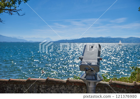 Panoramic Binocular Overlooking Bodensee Sailboats and Swiss Alps from Lindau, Germany. Scenic Summer View Captures European Vacation Paradise with Yacht Racing and Mountain Vistas. 121376980