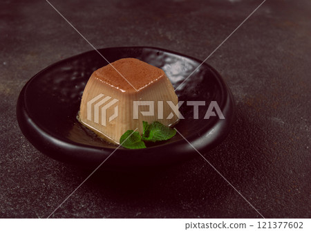 cream caramel pudding, with caramel sauce, dessert,breakfast, on a black plate, mint, no people, 121377602