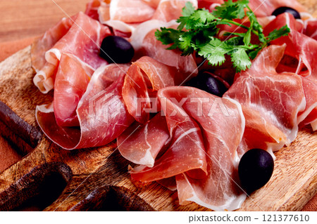 sliced prosciutto, on a cutting board, with olives and herbs, snack, breakfast, no people, sliced prosciutto, on a cutting board, with olives and herbs, snack, breakfast, no people, 121377610