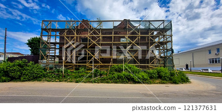 The historic building of 1914, Gostiny Dvor, is surrounded by wooden forests and overgrown plants. Kimry city, Tver region, 06/07/2023 mobile photo, no people 121377631