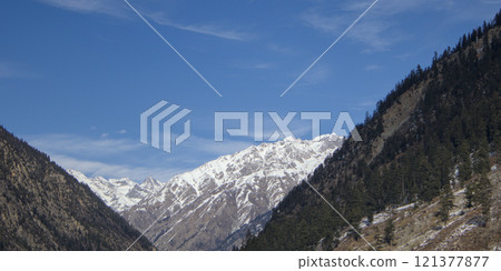 Wide-Angle Shot of a Snow-Capped Mountain Peak Framed by Forested Slopes Wide-Angle Shot of a Snow-Capped Mountain Peak Framed by Forested Slopes 121377877