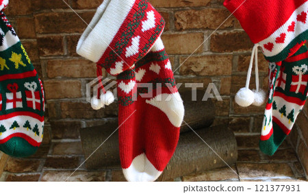 New Year's souvenir socks with a festive print on the background of brickwork in a fireplace with logs 121377931