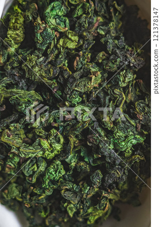 A CloseUp View of Dried Green Tea Leaves Artfully and Carefully Arranged in a Beautiful Container 121378147