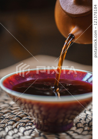 Artisan Tea Being Poured Gracefully into a Beautifully Handcrafted Bowl for Enjoyment Artisan Tea Being Poured Gracefully into a Beautifully Handcrafted Bowl for Enjoyment 121378184