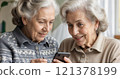 Two elderly women are learning how to use a mobile phone 121378199