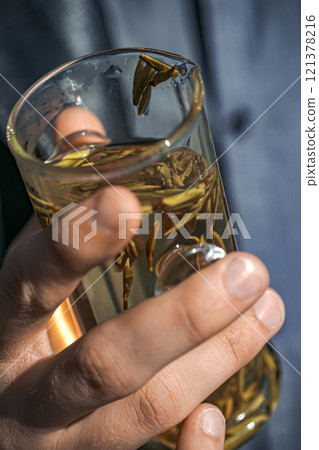 Holding a Beautiful Glass of Herbal Tea Made with Natural Ingredients and Flavors 121378216