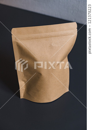 A Brown Paper Packaging Pouch Presented on a Dark Surface for Visual Appeal and Utility A Brown Paper Packaging Pouch Presented on a Dark Surface for Visual Appeal and Utility 121378223