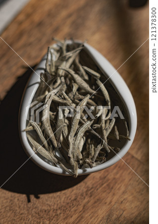Beautifully Arranged Dried Herbs Presented in a Sophisticated White Dish on Rustic Wooden Surface 121378300