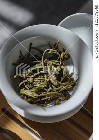 Delicate and Beautiful Green Tea Leaves Displayed in a Minimalist and Artistic Bowl 121378369