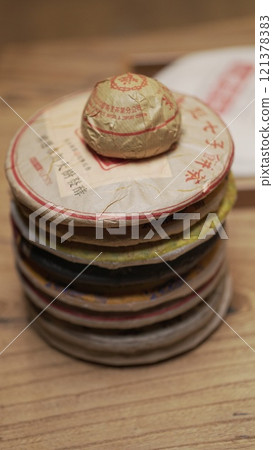 A collection of vintage discs gracefully stacked on a beautifully finished wooden surface 121378383