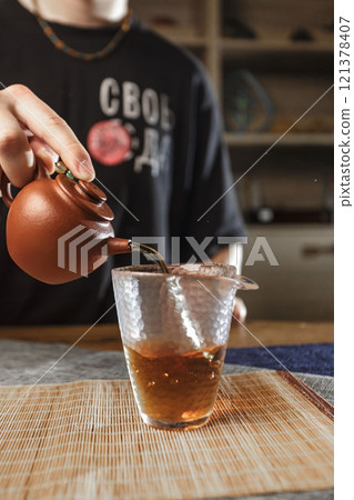 The art of pouring tea from a beautifully crafted traditional teapot brings immense joy The art of pouring tea from a beautifully crafted traditional teapot brings immense joy 121378407