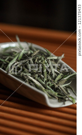 A Beautiful Display of Dried Green Tea Leaves Arranged on an Elegant and Stylish Dish 121378433