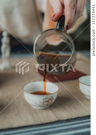 Delicate Tea Pouring in a Beautifully Serene and Tranquil Setting for a Perfect Experience Delicate Tea Pouring in a Beautifully Serene and Tranquil Setting for a Perfect Experience 121378441