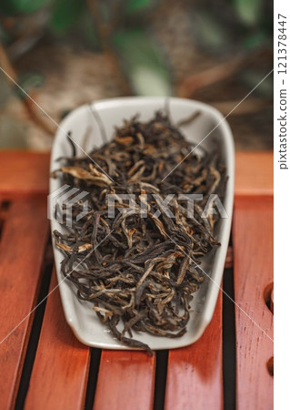 Beautifully Arranged Dried Tea Leaves in a Decorative Dish for an Elegant Presentation 121378447