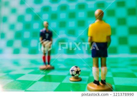 Soccer strategy concept with miniature referee and players on checkered field, tactical game setup Soccer strategy concept with miniature referee and players on checkered field, tactical game setup 121378990