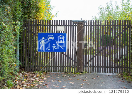 A pedestrian zone road sign hangs on the gate. 121379310
