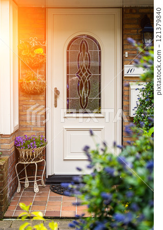 Facade of typical Dutch door house with brick walls, steps, front door windows. Doors on the street, Netherlands 121379840