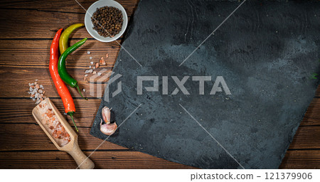 rustic cutting board with rosemary and spices , dark rustic wooden background, top view, place for text rustic cutting board with rosemary and spices , dark rustic wooden background, top view, place for text 121379906