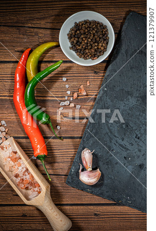 rustic cutting board with rosemary and spices , dark rustic wooden background, top view, place for text rustic cutting board with rosemary and spices , dark rustic wooden background, top view, place for text 121379907