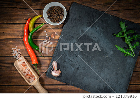 rustic cutting board with rosemary and spices , dark rustic wooden background, top view, place for text 121379910