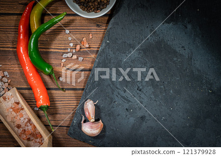 rustic steak cutting board with rosemary and spices , dark rustic wooden background, top view, place for text rustic steak cutting board with rosemary and spices , dark rustic wooden background, top view, place for text 121379928
