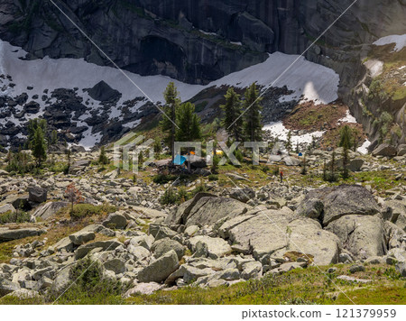 Camp is in the distance under a high cliff Camp is in the distance under a high cliff 121379959