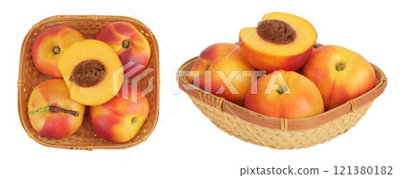 Ripe nectarine fruit with half in a wicker basket isolated on white background with full depth of field. Top view. Flat lay 121380182