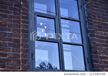 Classic windows in a brick house. Beautiful black windows in the house. 121380346