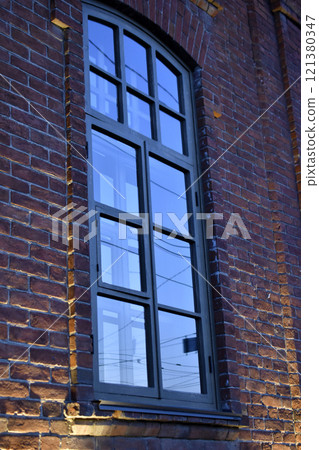 Classic windows in a brick house. Beautiful black windows in the house. Classic windows in a brick house. Beautiful black windows in the house. 121380347