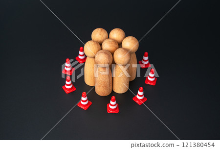 A group of people are surrounded by a barrier of traffic cones. Restrictions and control. Surveillance of personnel, despotic company policies. Management of society. Censorship, disregard for rights. 121380454