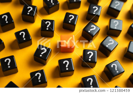 An orange check mark among many question marks. Correct answer. Task completion. Open achievement. Many unknown things and challenges. Fulfillment of requirements. 121380459