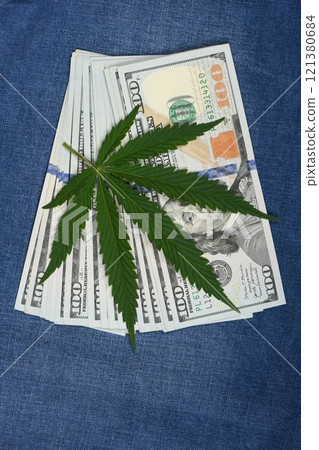 Hemp leaf in jeans background. Industrial hemp leaf on jeans fabric. Hemp leaf in jeans background. Industrial hemp leaf on jeans fabric. 121380684
