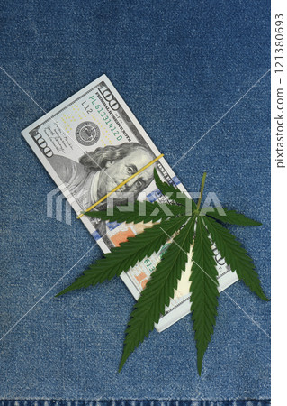 Hemp leaf in jeans background. Industrial hemp leaf on jeans fab Hemp leaf in jeans background. Industrial hemp leaf on jeans fab 121380693