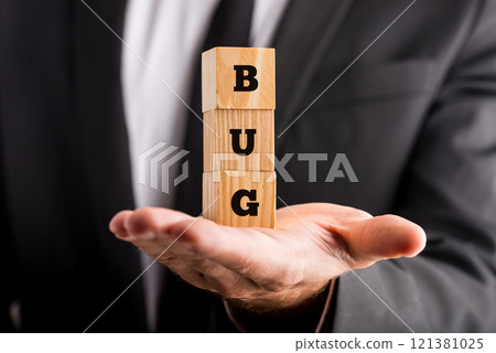 Businessman holding wooden blocks with the word Bug 121381025
