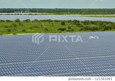 Aerial view of big sustainable electric power plant with many rows of solar photovoltaic panels for producing clean electrical energy. Renewable electricity with zero emission concept 121381091