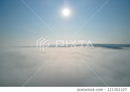 Aerial view from high altitude of earth covered with white puffy cumulus clouds on sunny day 121381107