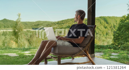 freelancer with laptop, enjoying nature, working remotely 121381264