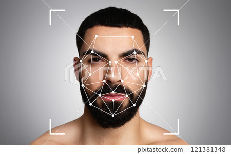 Middle eastern man is undergoing facial recognition analysis, with pattern mapping visible on his face against a neutral background. 121381348