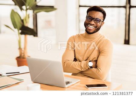 Successful Businessman. Happy black man smiling and sitting with crossed arms. Free space 121381377