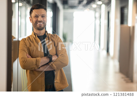 Successful Entrepreneurship. Happy Businessman Smiling To Camera Posing Crossing Hands Standing In Doorway Of Modern Office. Employment And Business Career Concept Successful Entrepreneurship. Happy Businessman Smiling To Camera Posing Crossing Hands Standing In Doorway Of Modern Office. Employment And Business Career Concept 121381488
