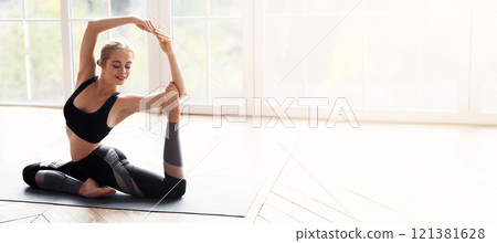 Health and beauty concept. Sporty flexible girl making advanced yoga pose at home in sun lights, copy space 121381628