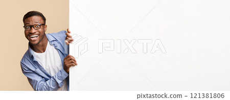 Funny Afro Man Looking Out Of White Blank Board For Text Standing Over Yellow Studio Background. Panorama, Mockup 121381806