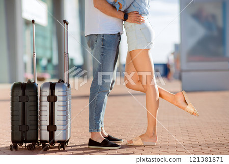 Relationship And Tourism Concept. Loving couple waiting for departure cuddling ouside, standing with luggage 121381871