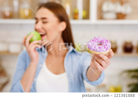 Healthy Eating. Girl Rejecting Junk Food, Choosing Fresh Apple, Focus on Donut 121381888