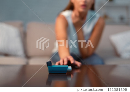 Unrecognizable Girl Reaching For Asthma Inhaler Preventing Attack Sitting On Sofa Indoor. Selective Focus, Shallow Depth 121381896