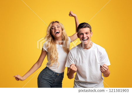 We did it. Euphoric young students celebrating successful passing exams, yellow studio background with free space 121381903